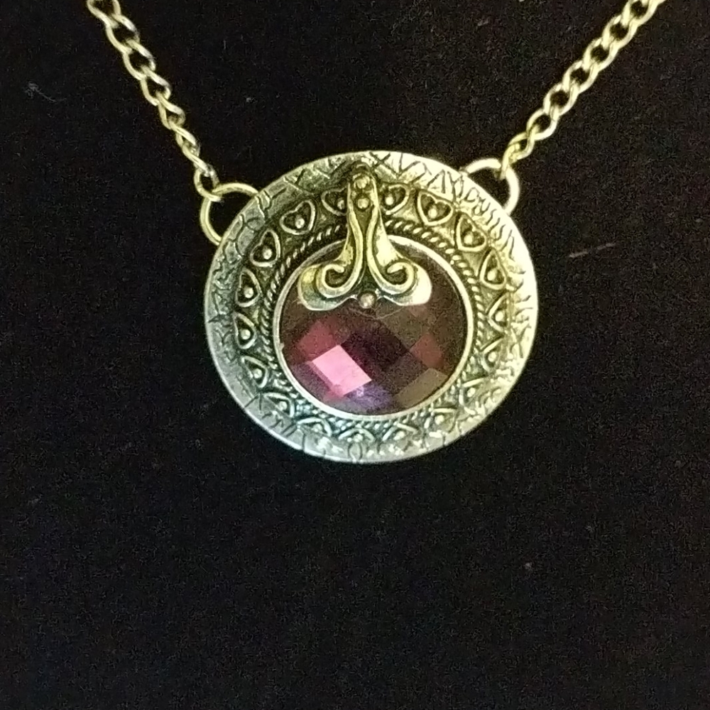 Purple glass jewel in ornate silver setting